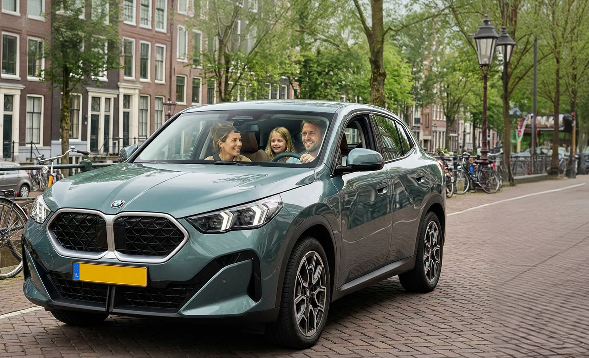 Familie in een groene BMW X2 op een Amsterdamse gracht — private lease met Yoyomove